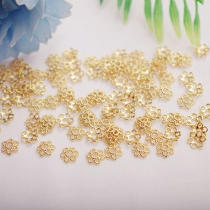 Detailed macro view of 14K gold hollow flower petal spacer beads for DIY jewelry making