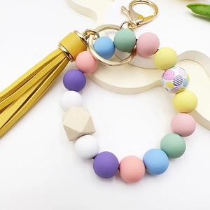 Detail of silicone bead bracelet with macaron colors, wooden bead and yellow tassel