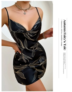 Détail d'une nuisette en satin noir avec motifs de feuilles dorées et décolleté en V