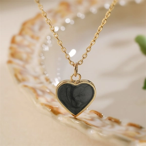 Elegant gold-tone chain necklace with a minimalist black enamel heart pendant for women