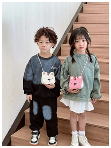 Children's cute bear crossbody bags in white and pink worn by kids on stairs