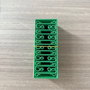 Detailed view of green S-shaped plastic ornament hooks for Christmas holiday decor