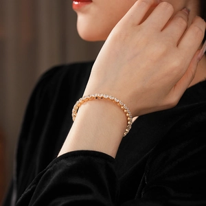 Detailed close-up of a luxury gold tennis bracelet with brilliant cubic zirconia on wrist