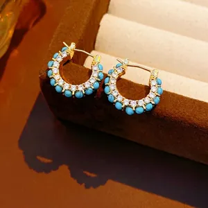 18k gold plated hoop earrings with turquoise beads and zircon on brown velvet display