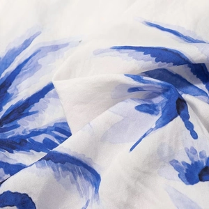 Macro detail of blue watercolor floral print on white breathable linen-blend fabric
