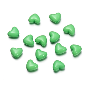 Detailed view of glossy light green acrylic heart-shaped beads for DIY jewelry making