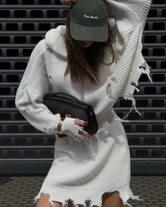 Détail de la robe à capuche en maille blanche avec déchirures artistiques et style grunge