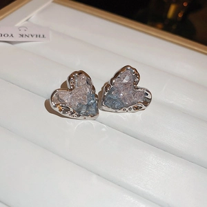 Detail of heart-shaped earrings with blue ice crystal texture and silver lava metal borders