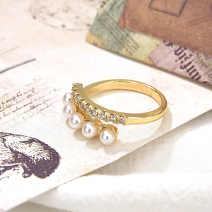 Baroque gold adjustable ring with pearls and zircons on vintage paper background
