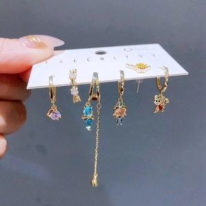Close-up of a 6-piece gold earring set with colorful crystals and long tassel details