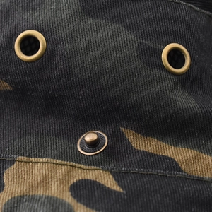 Macro view of camouflage sun hat featuring bronze metal eyelets and twill cotton texture