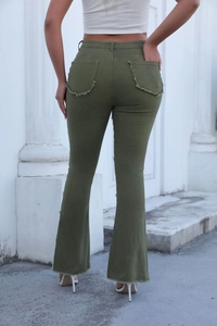 Détail d'un jean évasé vert armée avec ourlet effiloché et texture denim naturelle