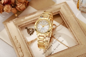 Gros plan sur la montre à quartz MODAIYA dorée avec cadran en cristal et lunette gravée