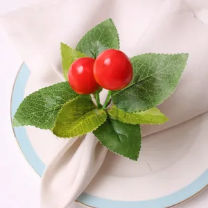 Detailed view of lifelike red cherries and green leaves on a festive napkin ring