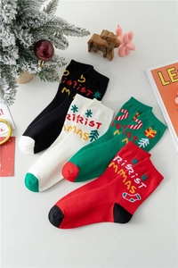 Dettaglio della trama a maglia di calze natalizie colorate con motivi di Babbo Natale