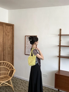 Close-up of yellow crochet bucket bag showing woven texture in a cozy home setting