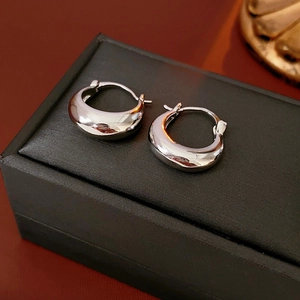 Polished silver U-shaped hoop earrings displayed on a professional black jewelry case