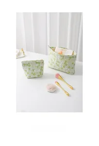 Quilted floral makeup bag set featuring a green floral pattern and two-piece storage design