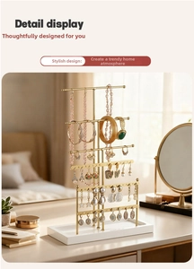 Detail display of a 6-tier gold jewelry organizer with necklace hooks and earring holes