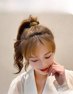 Close-up of matte gold wavy hair claw clip securing a high ponytail on model