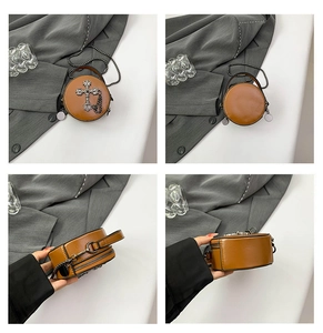 Brown round mini crossbody bag featuring a vintage silver metal cross and chain tassels