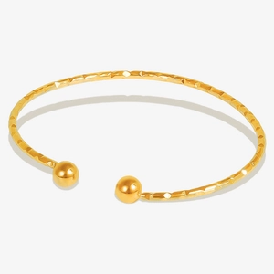 Detail of 18k gold plated stainless steel open bangle with textured hammer finish
