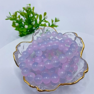 8mm purple pink gradient glass bead bracelet in a gold-rimmed petal-shaped glass bowl