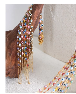 Macro detail of gold-plated evil eye charm bracelets with colorful enamel on dark wood
