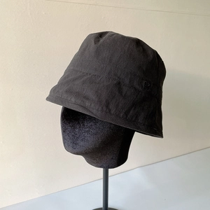 Lightweight black bucket hat for women with drawstring on a display stand
