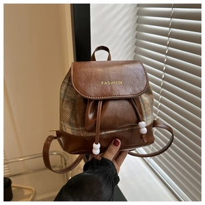 Detail eines Vintage-Rucksacks mit Karomuster-Patchwork, PU-Leder und Kordelzugverschluss