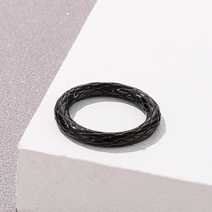 Detail of black woven texture and polished steel finish on a vintage snake scale ring