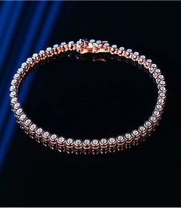 Rose gold moissanite tennis bracelet with round cut stones on a sleek black surface