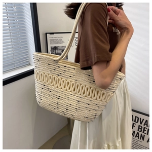 Detail of woven tote bag showing 3D wave texture and mixed fiber particles on cream strap