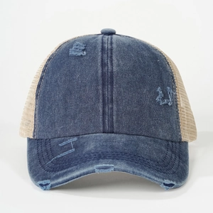 Distressed blue denim trucker hat with vintage torn details and beige mesh back design