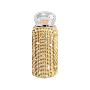 Luxury gold rhinestone covered stainless steel thermos flask with silver metal lid on white