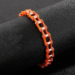 Detail of orange and silver stainless steel motorcycle chain bracelet on a black display