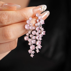 Close-up of dangling irregular pink gemstone tassel earrings with silver finish