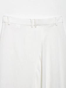 Detailed macro view of white acetate satin trousers waistline and belt loop stitching