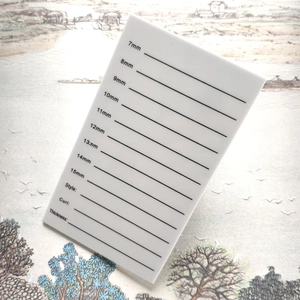 Macro view of white acrylic eyelash tray with length scales from 7mm to 15mm