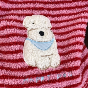 Close-up of pink striped plush fabric with cute cartoon dog patch and Happy Dog embroidery
