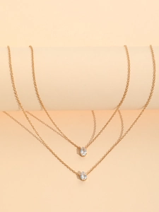 Detail of gold thin chain necklace featuring dual oval zircon pendants in a claw setting