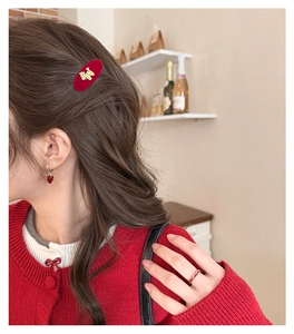 Detail of red flocked pony hair clip and matching heart jewelry on a female model