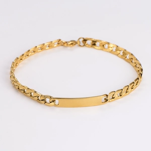 Detailed close-up of a golden Cuban chain bracelet with a blank polished nameplate bar
