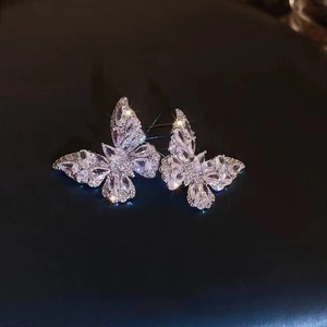 Elegant silver butterfly ear clips featuring sparkling cubic zirconia on black background