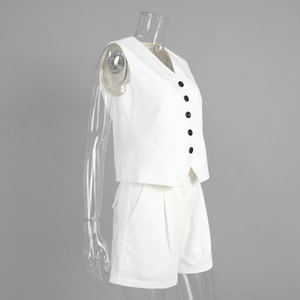 Detail of white V-neck waistcoat set with black buttons and high-waist shorts on model
