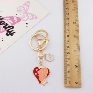 Detailed size measurement of golden fox heart keychain with ruler for scale reference