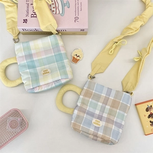 Close-up of cute plaid water bottle bags with yellow ruffled shoulder straps and brand labels