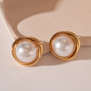 Gros plan sur les boucles d'oreilles perles vintage avec design de fils dorés torsadés