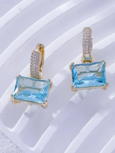 Detail of light blue emerald-cut zircon earrings with gold-plated micro-pave setting