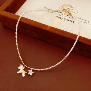 Elegant pearl necklace with unicorn pendant and gold star charm on velvet jewelry display
